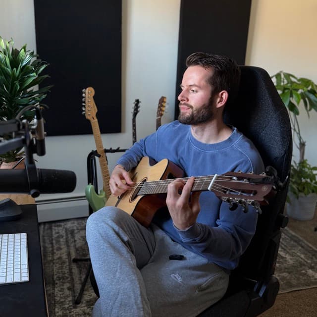 Dean playing guitar in his studio